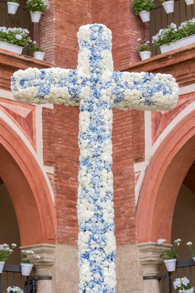 Large Christian cross covered with white and blue flowers for the City Crosses Festival